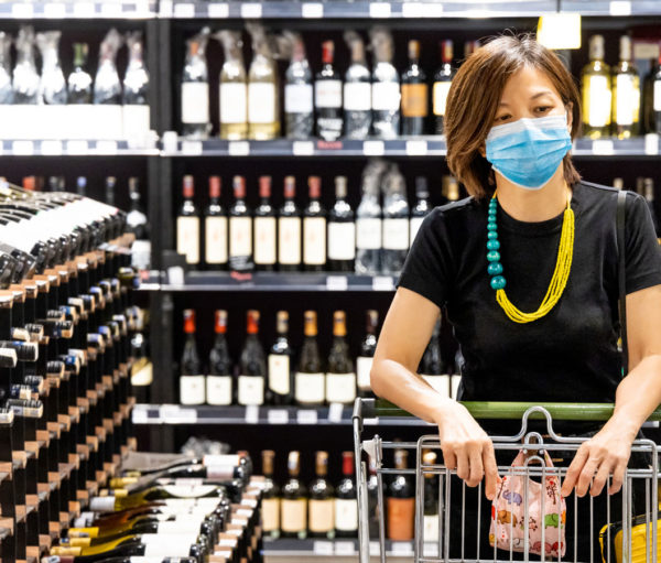 Woman with mask shopping in liquor store
